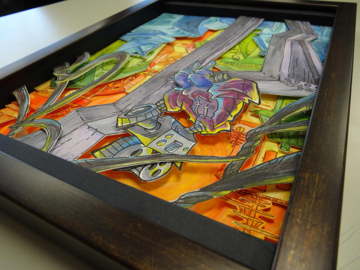 A photo of a colourful shadowbox. It depicts a robot with a camera for a head sitting atop a construction beam and watching over a city.