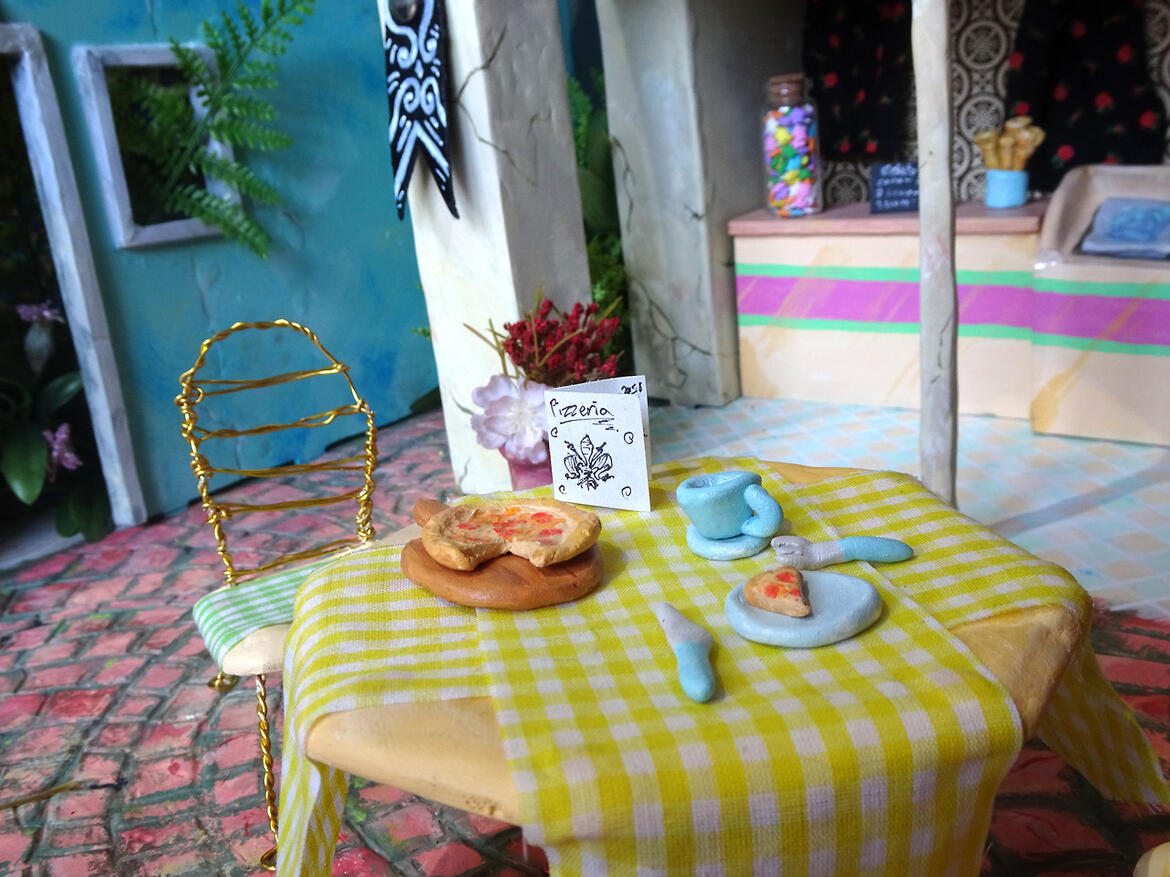A photo of miniature buildings, made to look like a small gelato street in Italy.